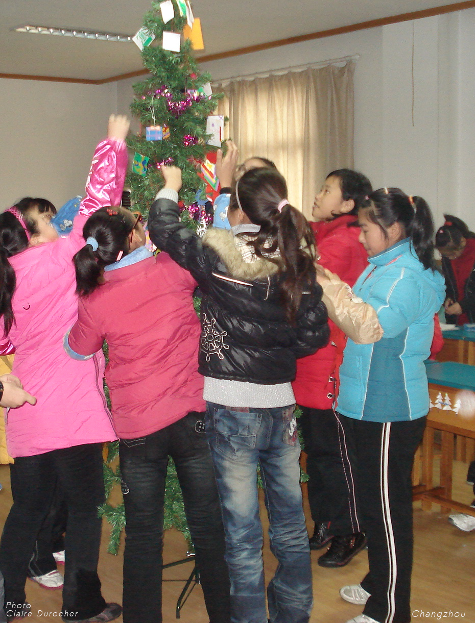 enfants décorant un sapin de Noël
