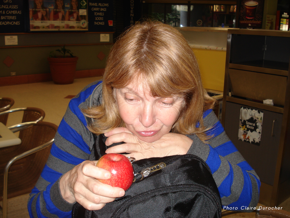 une femme montre une pomme dans un sac à dos